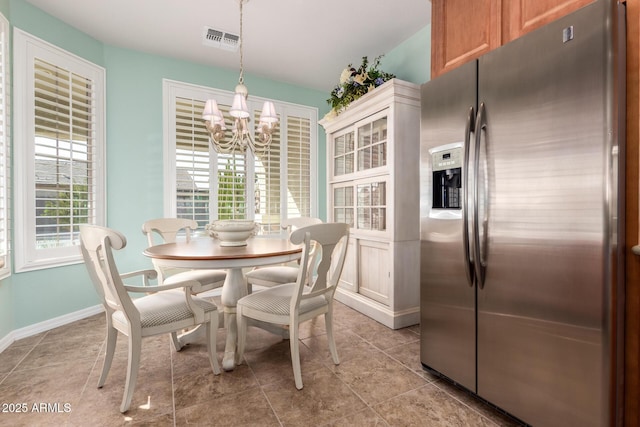 dining room with baseboards, light tile patterned flooring, visible vents, and a notable chandelier