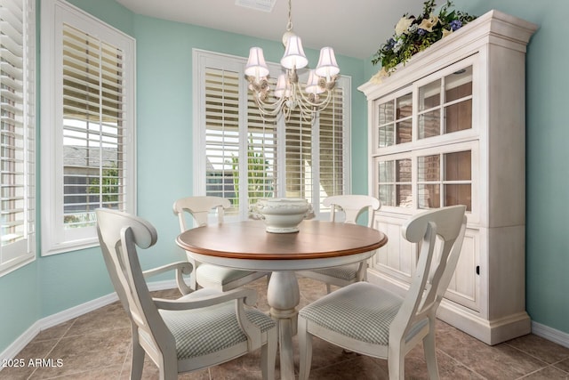 tiled dining space featuring baseboards, a wealth of natural light, and a notable chandelier