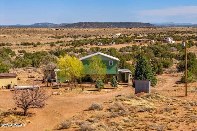 exterior space with a rural view, view of desert, and a mountain view