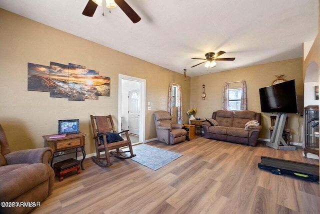 living room with baseboards, wood finished floors, and ceiling fan