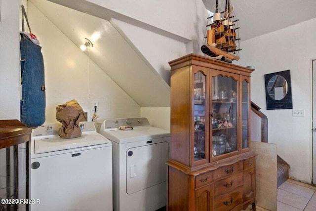 washroom featuring light tile patterned flooring, washer and dryer, and laundry area