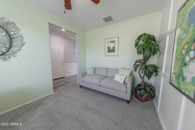 carpeted living area featuring ceiling fan, visible vents, and baseboards