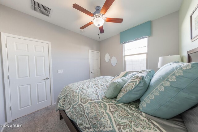 carpeted bedroom featuring ceiling fan and visible vents