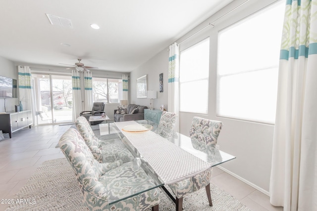 dining room with a ceiling fan, visible vents, baseboards, and light tile patterned floors