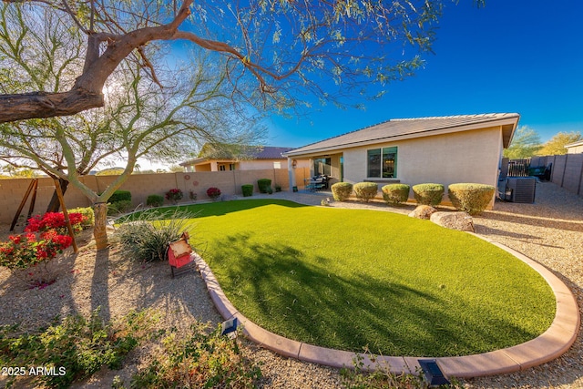 back of house featuring a patio, a fenced backyard, cooling unit, a yard, and stucco siding