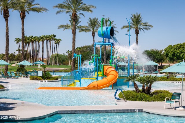 view of pool with playground community, a water play area, and a water slide