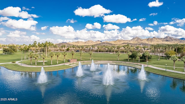 view of swimming pool with a lawn and a water and mountain view