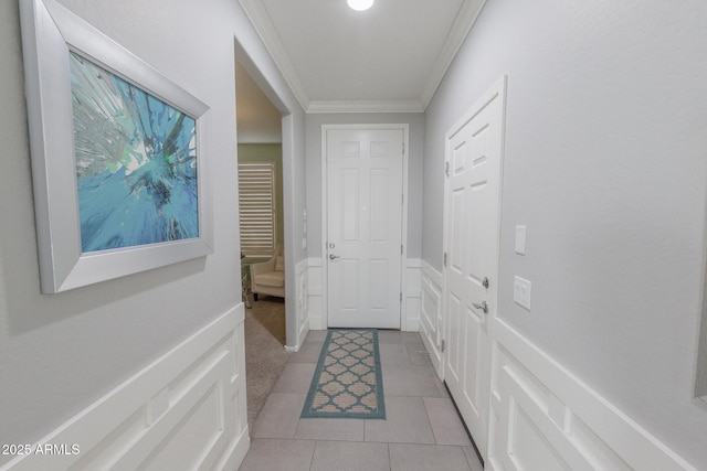 entryway with ornamental molding and light tile patterned flooring