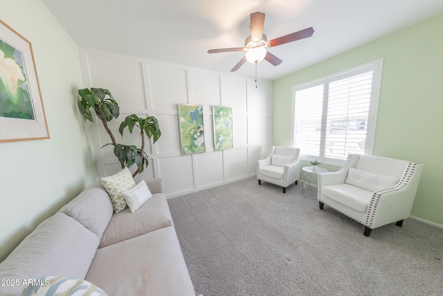 sitting room with carpet, a decorative wall, and a ceiling fan