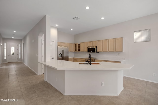 kitchen featuring light brown cabinets, appliances with stainless steel finishes, sink, and a spacious island