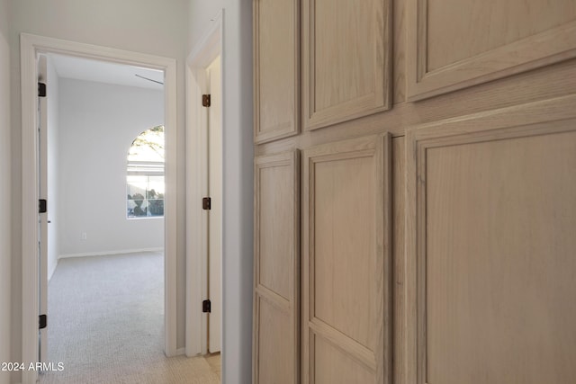 hall with light colored carpet