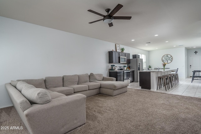 carpeted living room featuring ceiling fan and sink