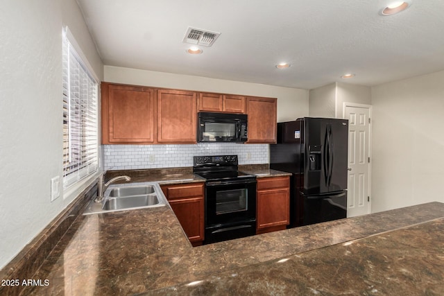 kitchen with decorative backsplash, visible vents, a sink, and black appliances