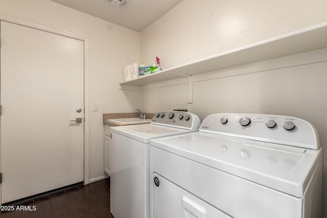 washroom featuring cabinet space, visible vents, dark wood finished floors, washer and dryer, and a sink