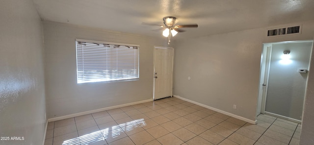 spare room featuring ceiling fan and light tile patterned floors