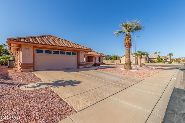 mediterranean / spanish house with a tiled roof, central AC unit, a garage, and stucco siding