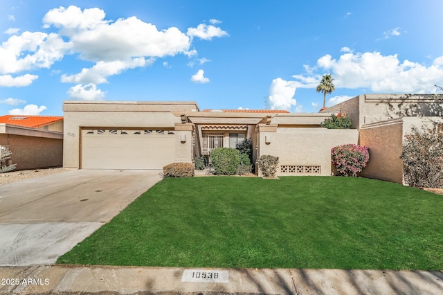 view of front of property featuring a front yard, concrete driveway, an attached garage, and stucco siding