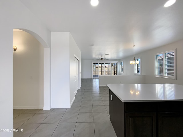 kitchen with light tile patterned floors, open floor plan, a center island, light countertops, and pendant lighting