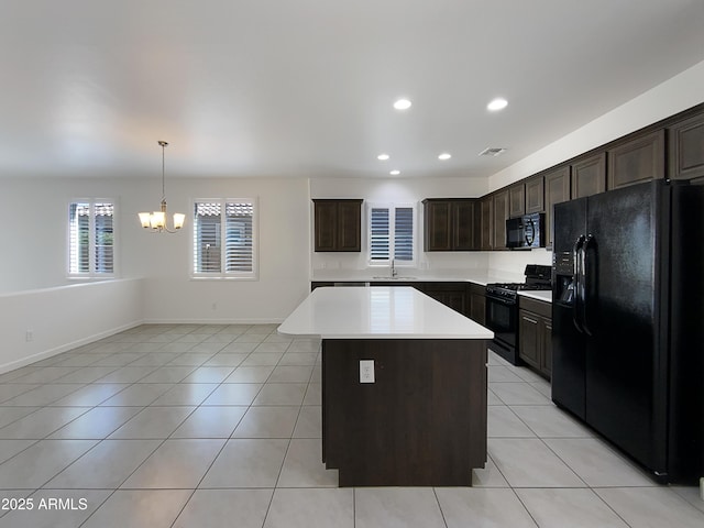 kitchen with light tile patterned floors, light countertops, a kitchen island, a sink, and black appliances