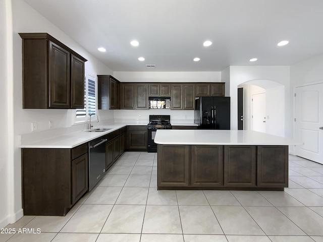 kitchen with black appliances, a kitchen island, light countertops, and a sink