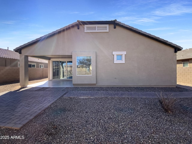 back of property with a patio area, fence, a tile roof, and stucco siding