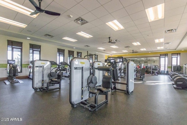 exercise room featuring visible vents, a paneled ceiling, and a ceiling fan