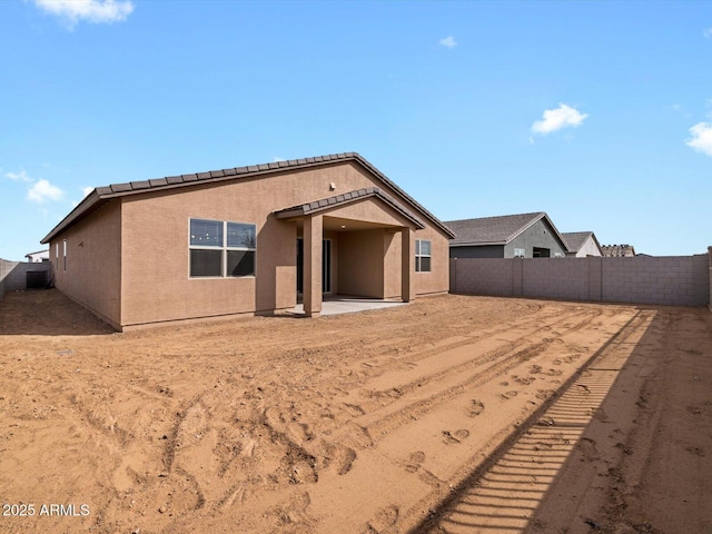 back of property with a fenced backyard, a patio, and stucco siding