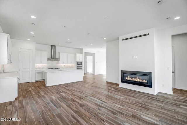 3310 Iron King Cir, Prescott, AZ 86301 - kitchen with wall chimney range hood, open floor plan, white cabinets, decorative backsplash, and stainless steel appliances