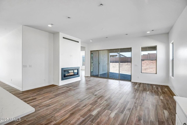 3310 Iron King Cir, Prescott, AZ 86301 - unfurnished living room featuring a glass covered fireplace, recessed lighting, baseboards, and wood finished floors