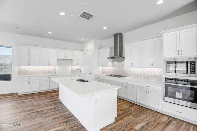 3310 Iron King Cir, Prescott, AZ 86301 - kitchen featuring wall chimney range hood, visible vents, a sink, wood tiled floor, and stainless steel appliances