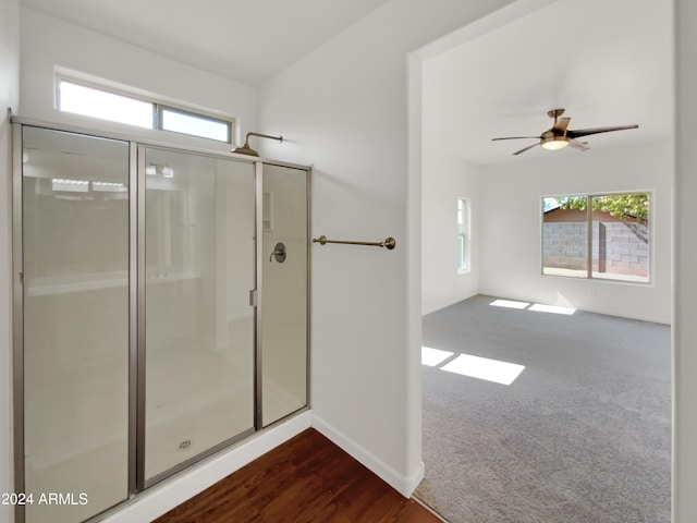 bathroom with ceiling fan, hardwood / wood-style floors, and a shower with door