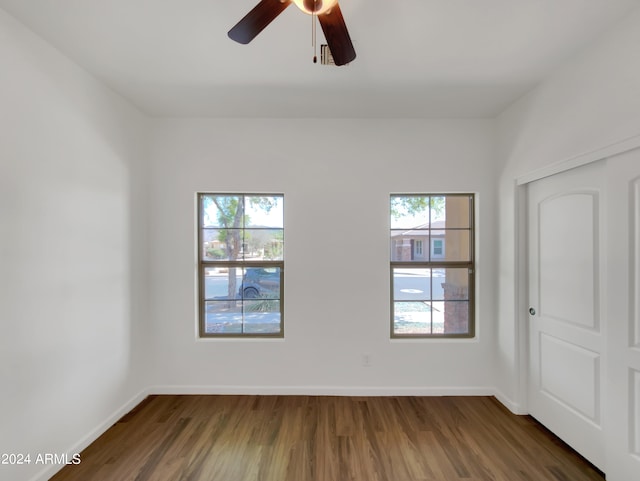 spare room with dark hardwood / wood-style flooring and ceiling fan