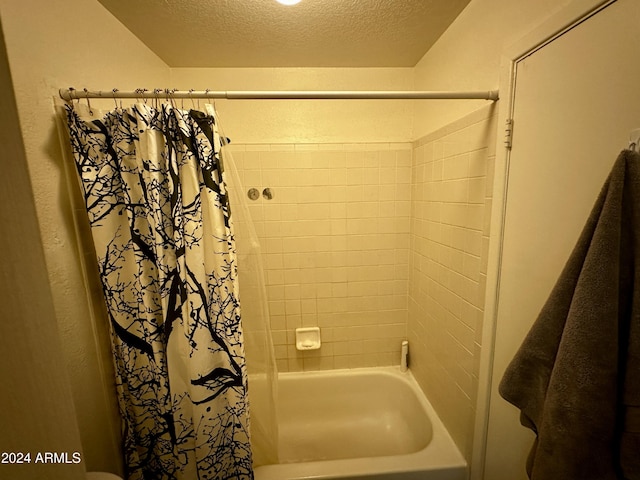 bathroom featuring shower / tub combo and a textured ceiling