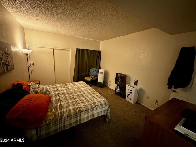 bedroom with a closet, a textured ceiling, and dark colored carpet