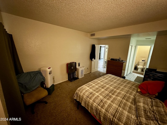 bedroom with carpet flooring, ensuite bathroom, and a textured ceiling