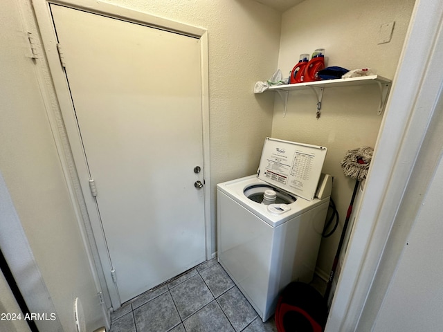 clothes washing area with washer / dryer and light tile patterned floors