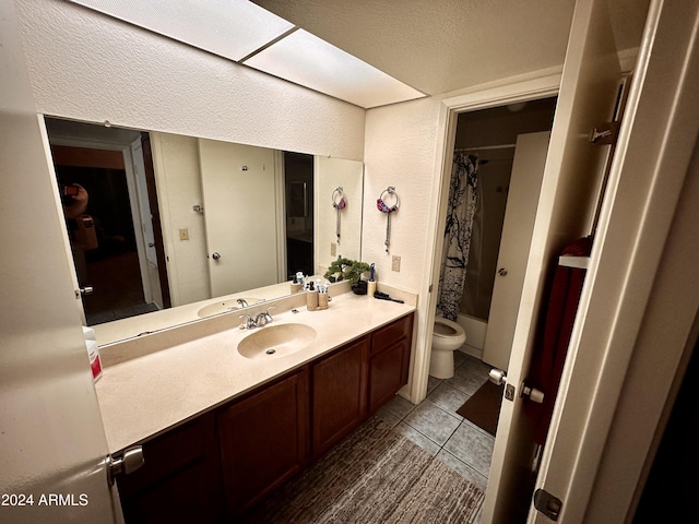 full bathroom featuring shower / bath combo, tile patterned floors, vanity, a textured ceiling, and toilet