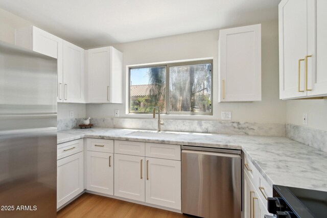 7500 E Deer Valley Rd Unit 132, Scottsdale, AZ 85255 - kitchen with stainless steel appliances, a sink, white cabinetry, light stone countertops, and light wood-style flooring