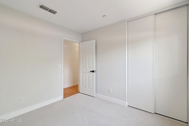 7500 E Deer Valley Rd Unit 132, Scottsdale, AZ 85255 - unfurnished bedroom featuring light carpet, baseboards, and a closet