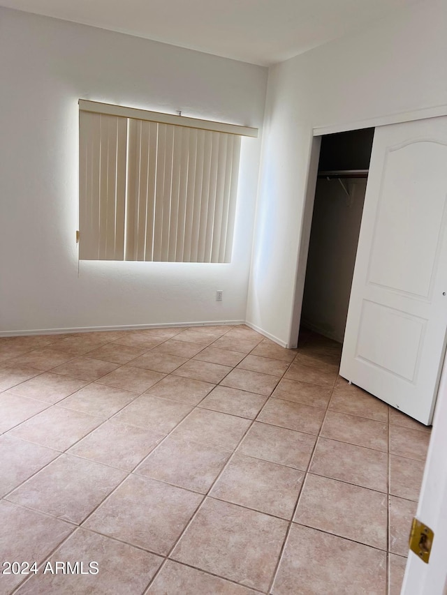 unfurnished bedroom with a closet and light tile patterned flooring