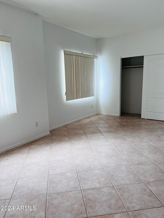 unfurnished bedroom with a closet and light tile patterned flooring