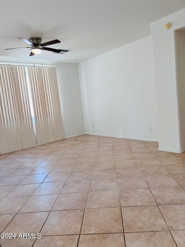 tiled empty room featuring ceiling fan