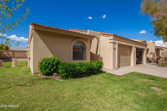 view of front of house featuring stucco siding, an attached garage, a front yard, fence, and driveway