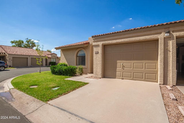 mediterranean / spanish home featuring a tile roof, driveway, an attached garage, and stucco siding