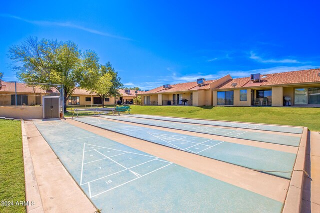 view of community featuring shuffleboard and a yard