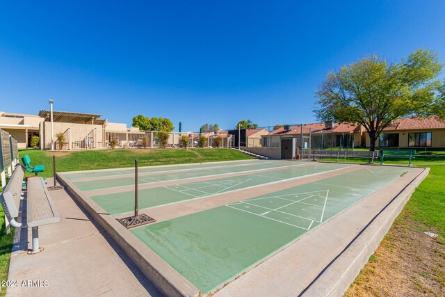 view of community with fence, shuffleboard, a lawn, and a residential view