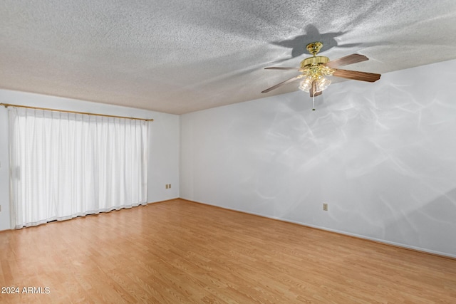 empty room with a textured ceiling, ceiling fan, and light wood-style flooring