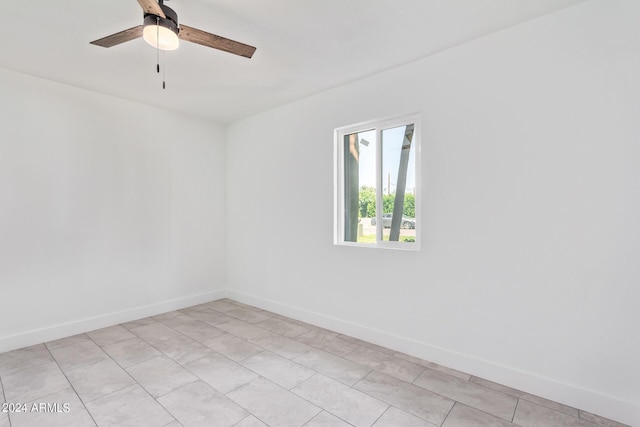 empty room featuring ceiling fan and light tile patterned floors