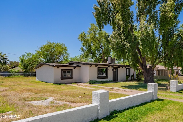 ranch-style house with central AC unit and a front yard