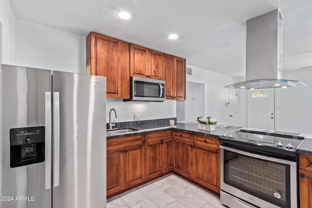 kitchen featuring dark stone counters, sink, a textured ceiling, island exhaust hood, and stainless steel appliances